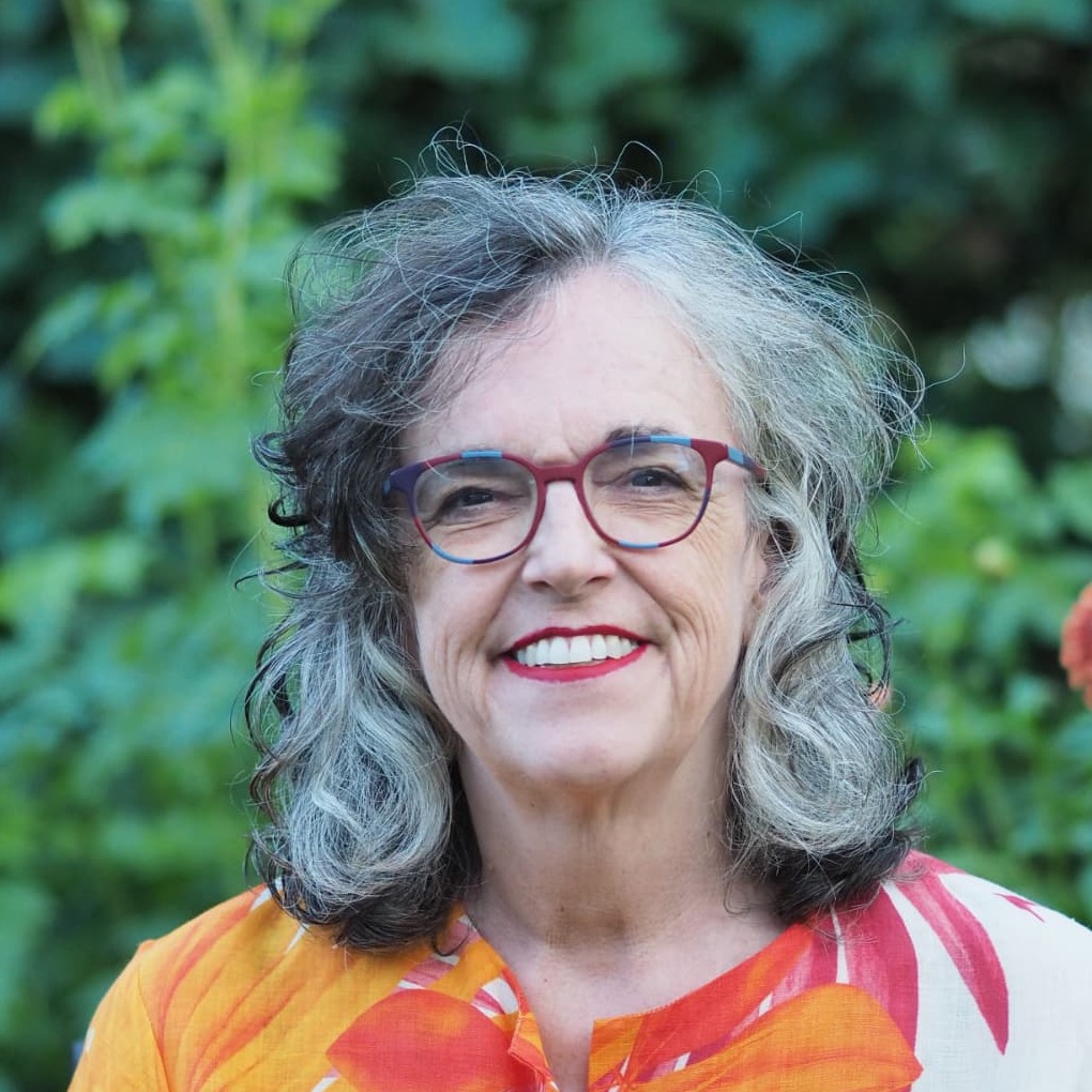 Portret van Corien Harder, lachend tussen de bloemen